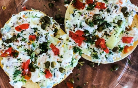 Toasted bagel with smoked salmon spread, tomatoes, capers, and fresh dill.