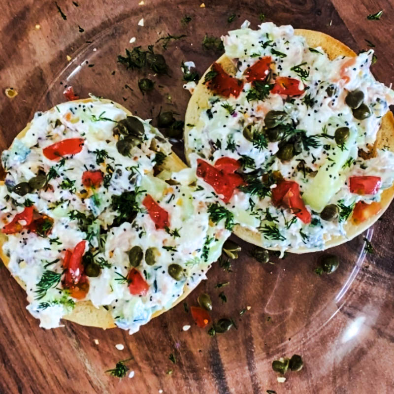 Toasted bagel with smoked salmon spread, tomatoes, capers, and fresh dill.